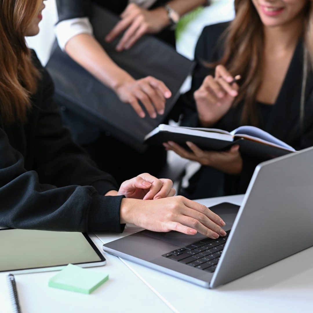 A group of professionals collaborating over a laptop and documents.